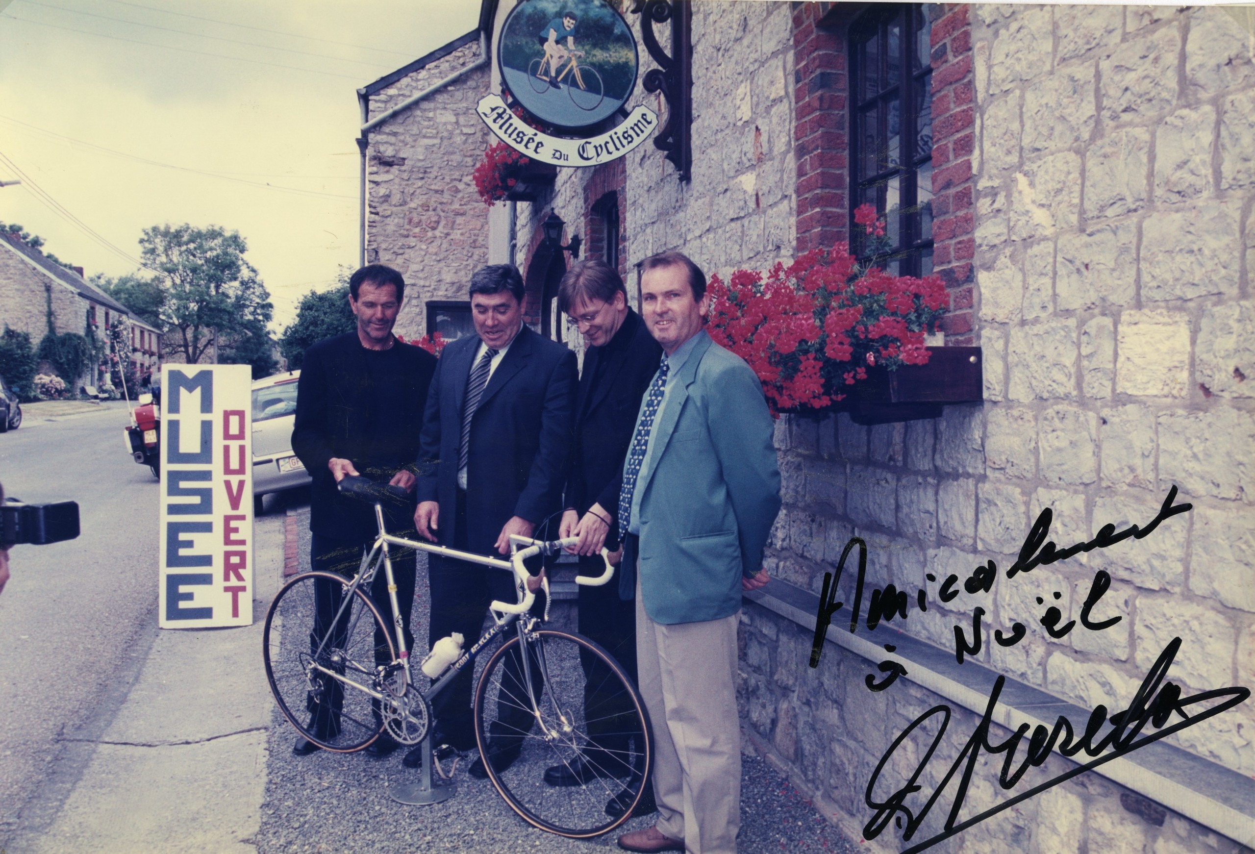 Noël Grégoire poseert samen met Roger De Vlaeminck, Guy Verhofstadt en Eddy Merckx bij zijn museum